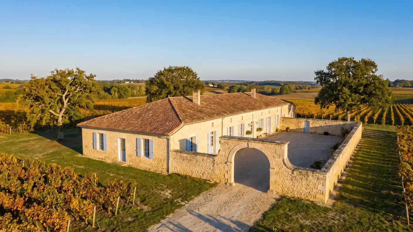 Una casa típica de la Charente a las afueras de Birac, una amplia vivienda de piedra color miel con tejado de tejas y una puerta monumental