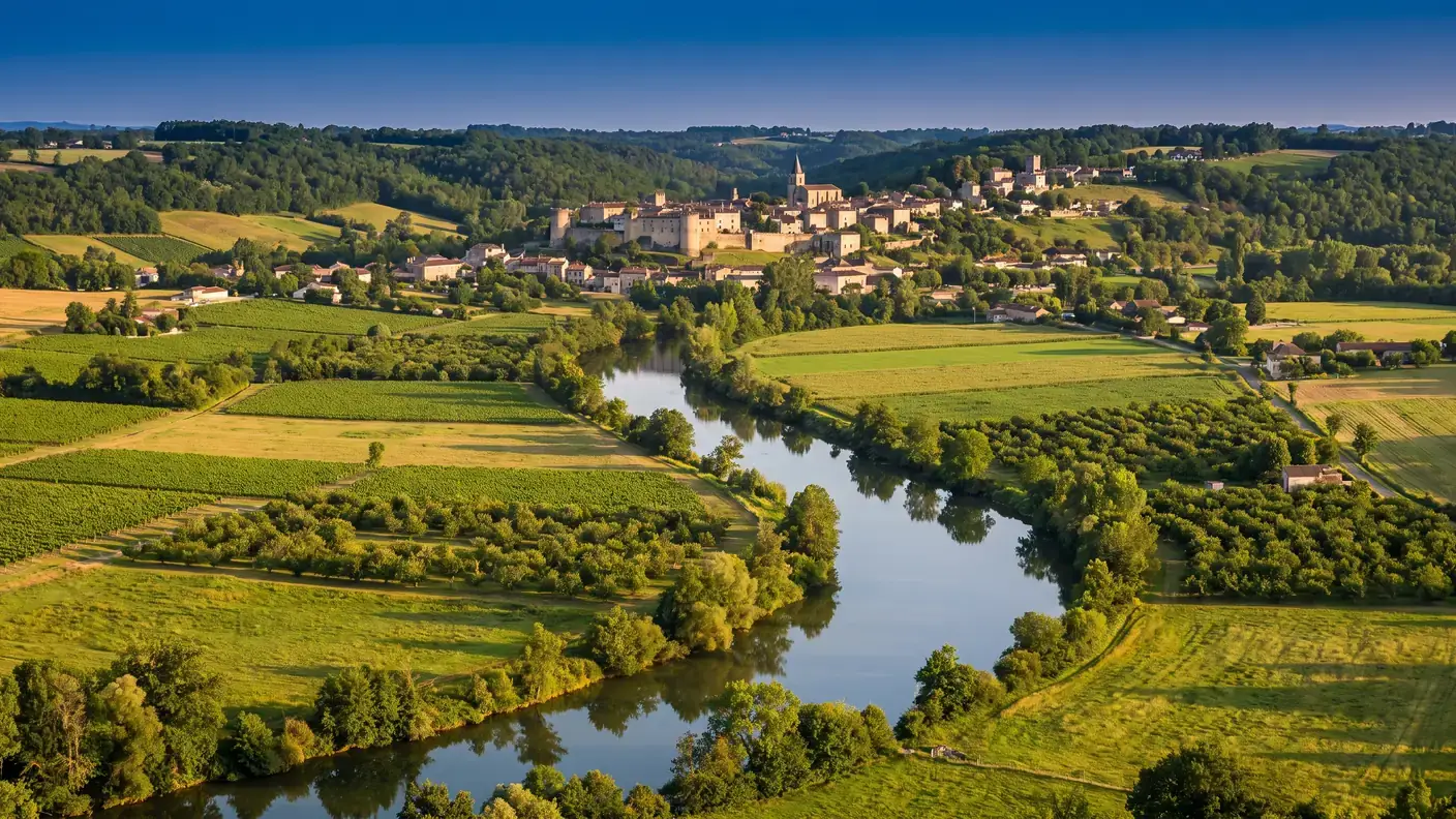 El verde valle del Dropt, en el Haut-Agenais, con campos y huertos dispuestos en forma de damero, y una bastida encaramada en la lejanía