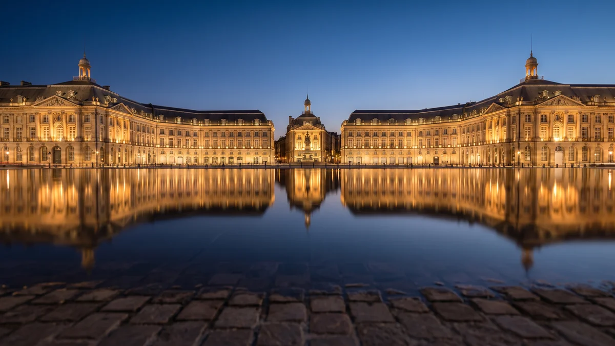 La plaza de la Bolsa reflejada en el Espejo de Agua de Burdeos al caer la noche