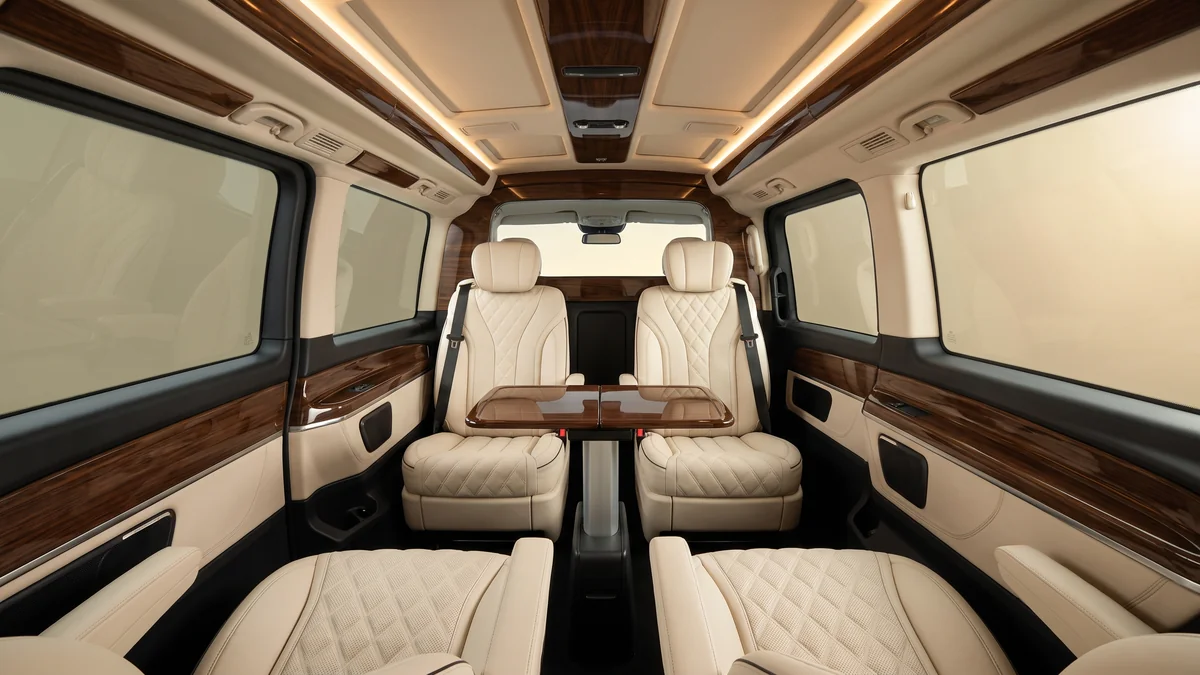 Leather interior of a chauffeur-driven van, with individual seats and ambient lighting