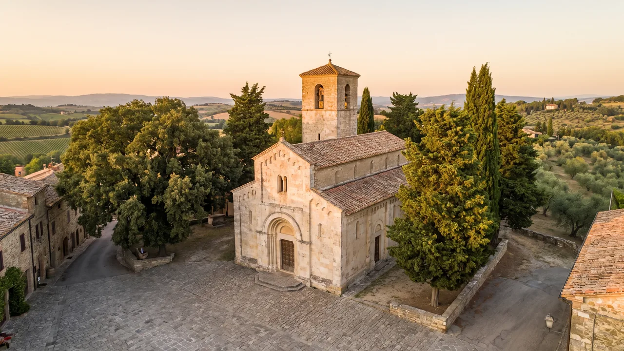 Iglesia románica de piedra clara en Chef-Boutonne, con campanario cuadrado y portal de arco de medio punto a orillas de una plaza