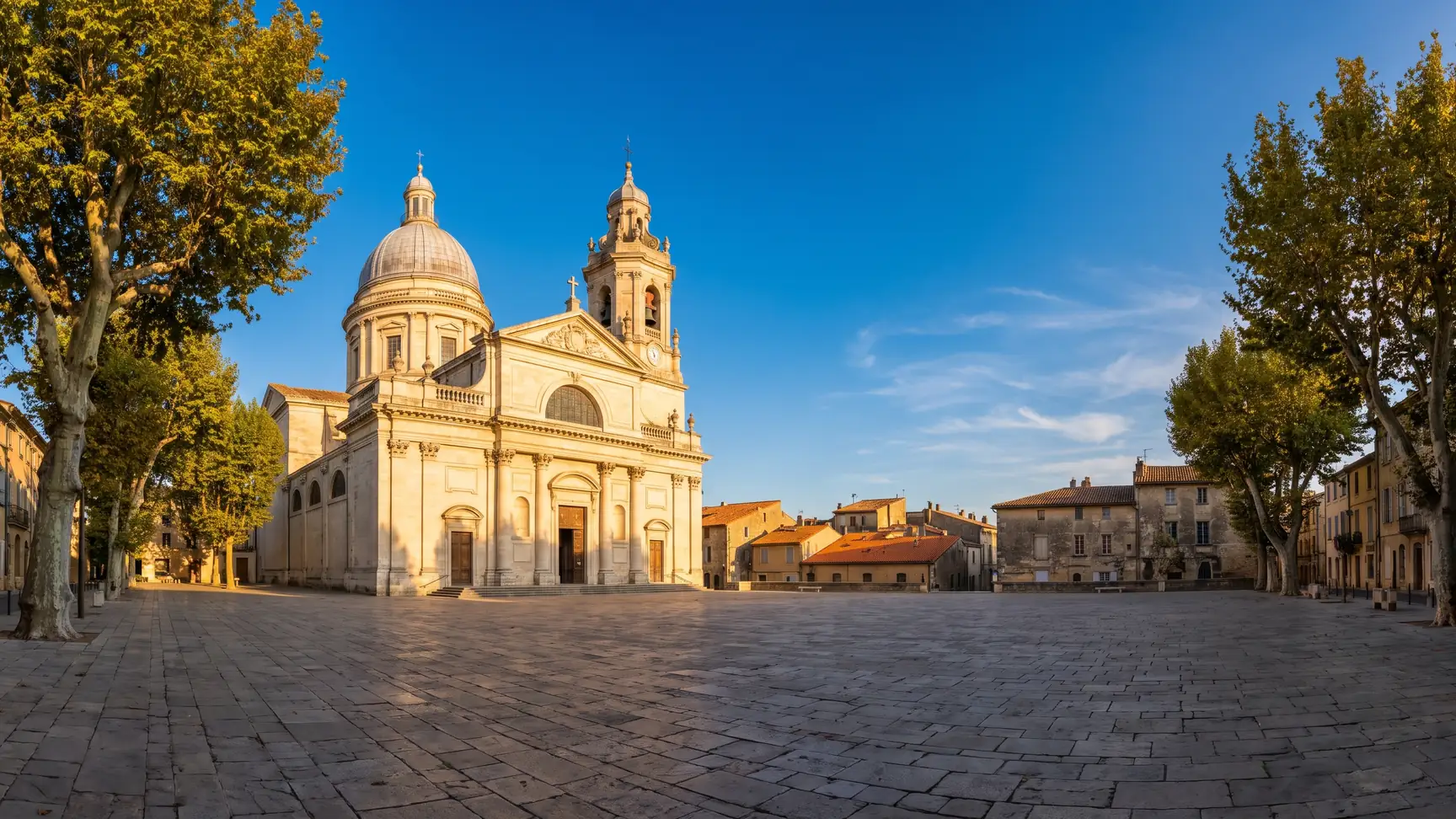 Una catedral clásica con cúpula y campanario de piedra clara que se eleva sobre los tejados de una ciudad del suroeste
