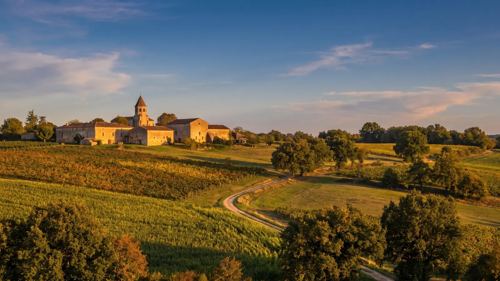La campiña ondulada del Bajo Armagnac, con viñedos, campos y bosques de robles que rodean una granja, en las Landas