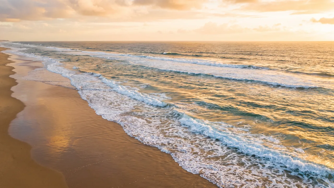 Largas olas del Atlántico que rompen en espuma en una playa desierta de Hourtin al atardecer, agua turquesa
