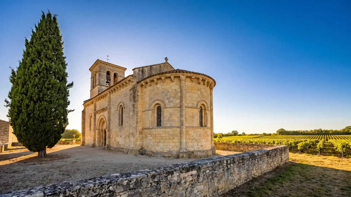 Iglesia románica de piedra en medio de los viñedos de Lussac
