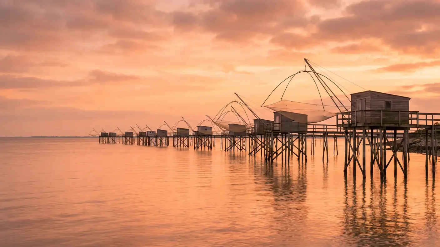 Carrelets, cabañas de pescadores sobre pilotes en el estuario de la Gironda al atardecer