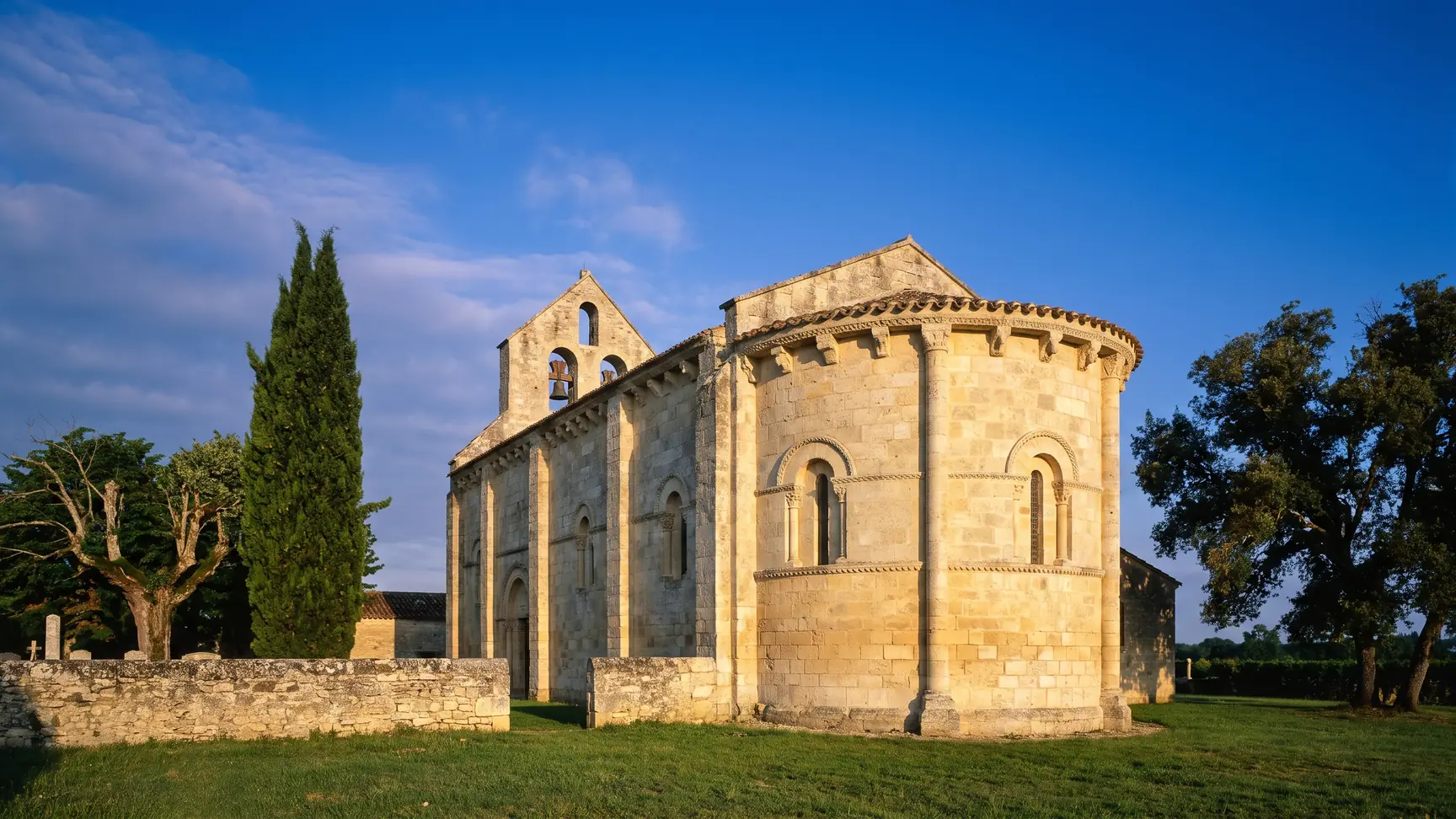 Una pequeña iglesia románica de los siglos XI y XII, construida en piedra de color miel, con cabecera redondeada con ménsulas esculpidas y campanario