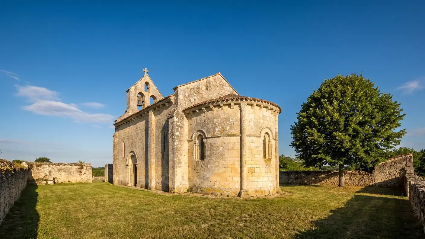 Una pequeña iglesia románica de la región de Saintonge, construida en piedra caliza clara, con una sola nave y un ábside redondeado